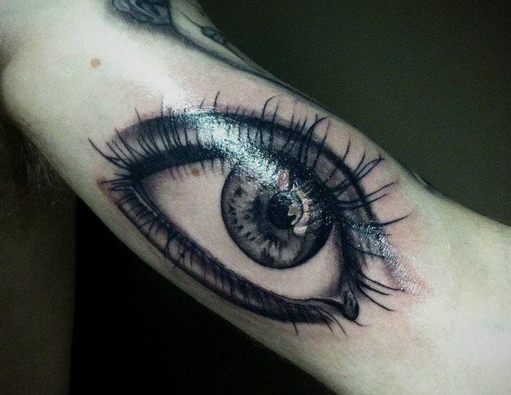 eye tattoo realism, black and grey by award winning artist, real eye tattoo on upper arm, large inner arm tattoo